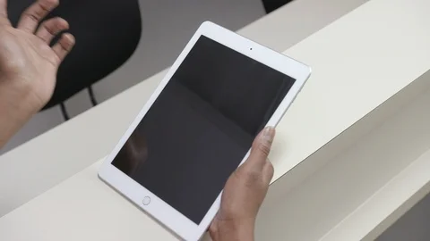 Over the shoulder shot of  iPad or tablet held by a female nurse, hand motions Stock Footage 109503981