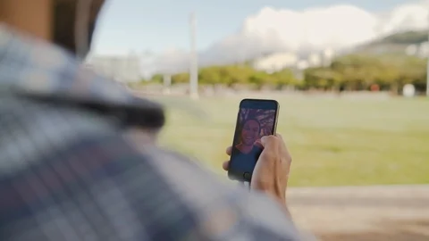 Over the shoulder shot of man chatting online - making video call on his smart Stock Footage 123224994