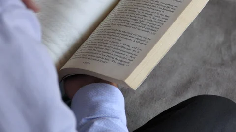 Over the shoulder shot of a man sitting on a chair and flipping the pages Stock Footage 146986514
