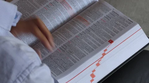 Over the shoulder shot of a man sitting on a chair and flipping the pages Stock Footage 147008976