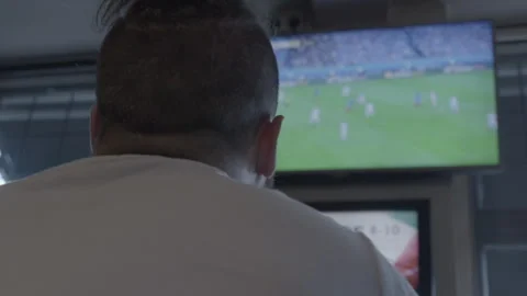 Over shoulder shot of a man watching a football match on TV Stock Footage 342564905
