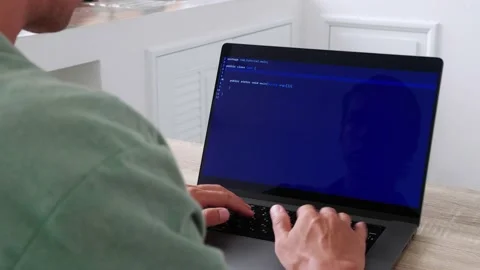 Over the shoulder shot of programmer developer freelancer writing code at a Stock Footage 197411600