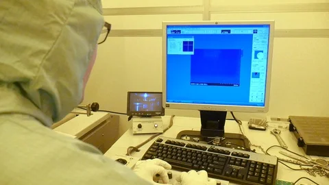 An over shoulder shot of a scientist working on a microscope in a Vidéo 94569992