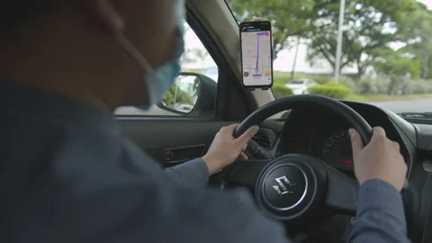 Over The Shoulder Shot Of Uber Driver Wearing Face Mask, Driving And Using Vídeo Stock 142525782