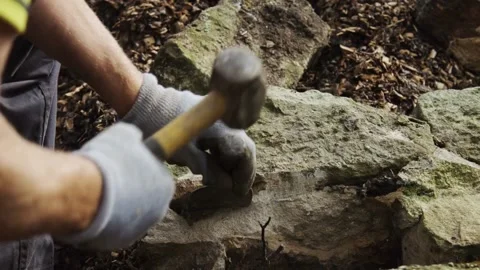 Over the Shoulder Shot of Waller Breaking Stone with Hammer and Chisel in 4K Stock Footage 280484321
