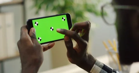 Over shoulder view on the African American male hands holding black smartphone Stock Footage 83062683