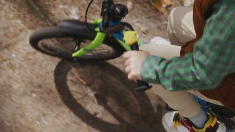 Over shoulder view boy holding handlebar while cycling Stock Footage 316581192