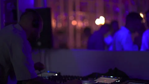 Over the Shoulder View of DJ Performing Live Set with Headphones 4K Video stock 329226388