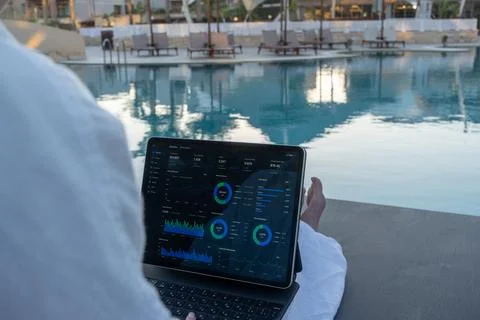 Over Shoulder View of Financial Analytics App on Tablet Screen Poolside Stock Photos