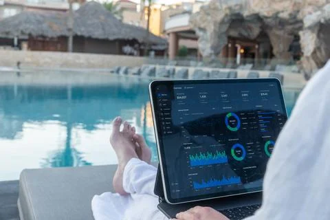 Over Shoulder View of Financial Analytics App on Tablet Screen Poolside Фото