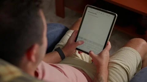 Over the Shoulder View of a Man Using a Tablet at Home Vídeos de archivo 347335486