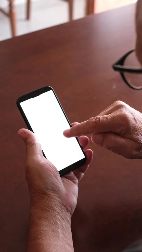 Over the shoulder view of an older man with glasses holding a modern Video stock 344642611