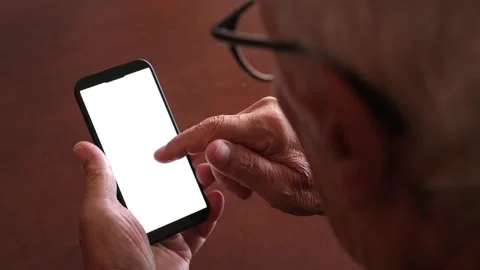 Over the shoulder view of an older senior man with eyeglasses using a mobile Stock Footage 344396405