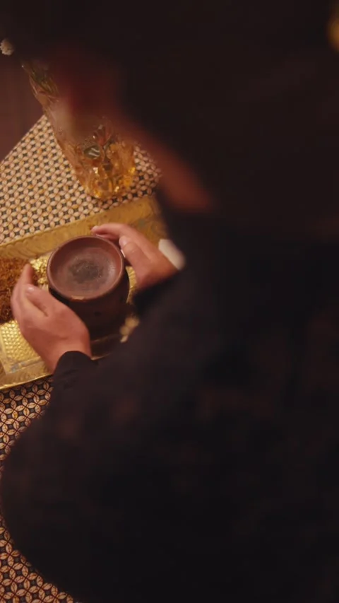 Over-the-Shoulder View of Person Drinking from Clay Pot Stock Footage 262526803