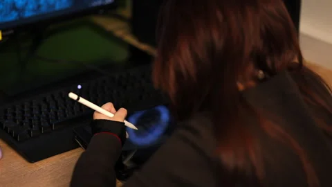 Over the shoulder view of a person using a digital tablet and stylus at a desk Stock Footage 335249484