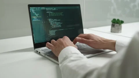 Over the shoulder view of professional developer coding in laptop working in IT Stock Footage 228989236