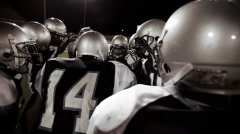 Over the shoulder view of a quarterback in the huddle and walking to the line Stock Footage 33871244