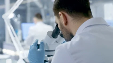 Over the Shoulder View of a Research Scientist Looking into Microscope.  Stock Footage 75444822