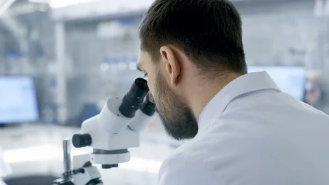 Over the Shoulder View of a Research Scientist Looking into Microscope.  Stock Footage 75445256