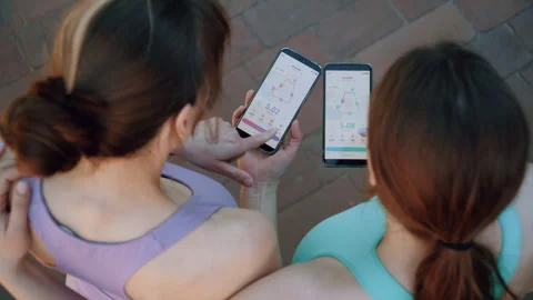 Over-the-Shoulder View of Sisters Checking Training Data Outdoors Vidéo 336962051