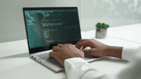 Over-the-shoulder view of smart focused efficient man typing on keyboard using Видео 228863532