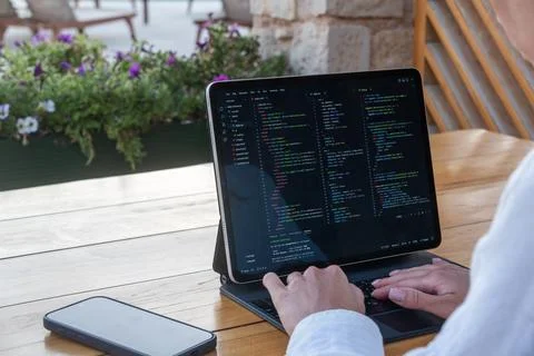 Over Shoulder View of Software Developer Coding on Tablet at Outdoor Cafe Fotos Stock