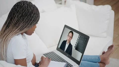 Over shoulder view of student video conferencing. Disciple works with the Vidéo 140867967