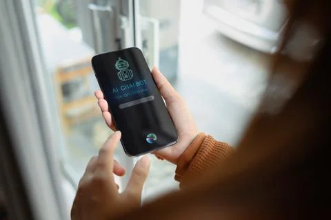 Over shoulder view of woman using AI Chat bot in mobile application and giving 스톡 사진