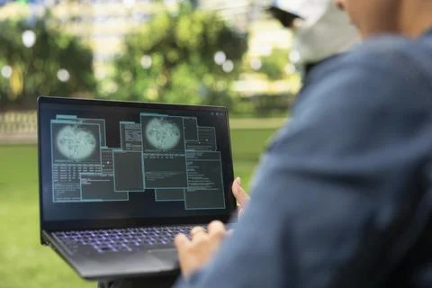 Over-the-shoulder view of woman using laptop with layered security windows Stock Photos