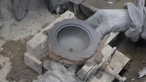 Over the shoulder view of a worker inspecting a finished circular graphite mold Stock Footage 332230533