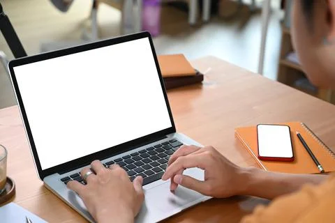 Over shoulder view of young man using laptop computer at home. Stock Photos