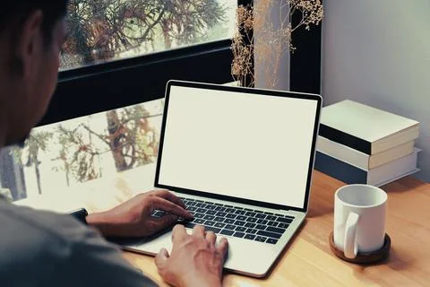 Over shoulder view of young man freelancer working with laptop computer at home. Stock Photos