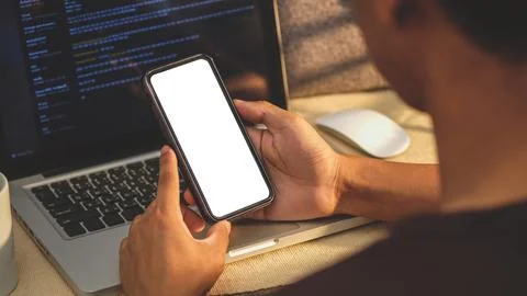 Over shoulder view of young man holding smart phone with blank screen. Stock Photos