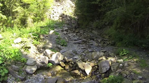 Up  over small gorge in mountains with  stream .Aerial    Vidéo 43099924