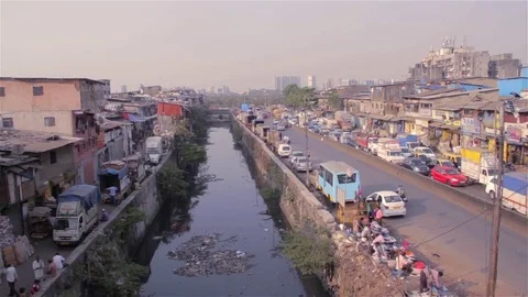 Over the top shot of vehicles passing on a road beside a nullah, India Stock Footage 72476986