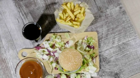 Over top view Delicous home made hamburger with fries on wooden table Stock Footage
