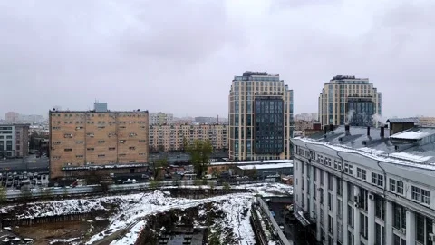 Overcast cityscape with roofs covered in light spring snow Stock Footage 336959551