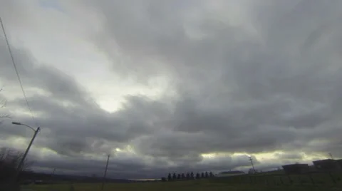 Overcast clouds over farm with sun peaking out Stock Footage 33865884