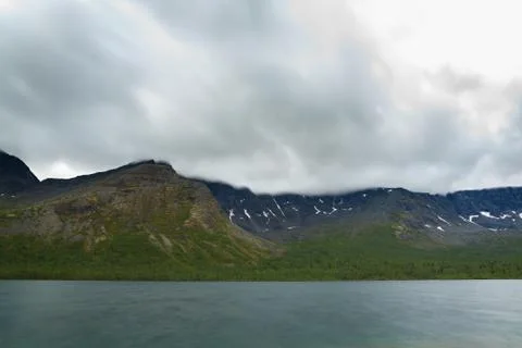 Overcast cloudy sky over the lake and mountains Khibiny. Stock-Fotos