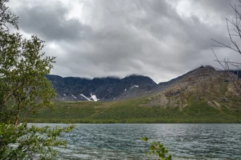 Overcast cloudy sky over the lake and mountains Khibiny. Stock Photos