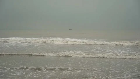 Overcast day on the beach with the small waves and muddy water 動画素材 169522353