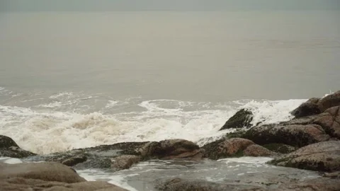 Overcast day on the beach with the small waves and muddy water 動画素材 169522954