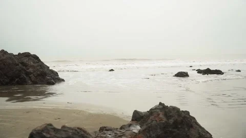 Overcast day on the beach with the small waves and muddy water 動画素材 169522959