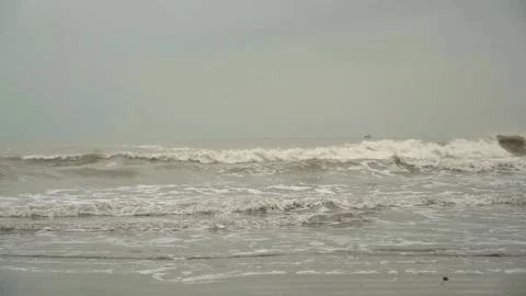Overcast day on the beach with the small waves and muddy water 動画素材 169523132