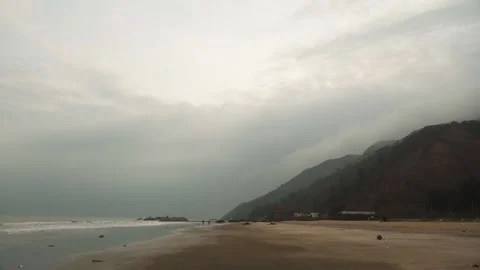 Overcast day on the beach with the small waves and muddy water 動画素材 169523495