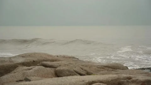 Overcast day on the beach with the small waves and muddy water 動画素材 169523902