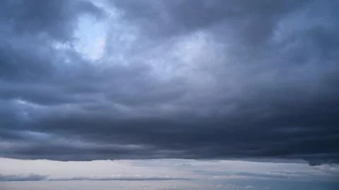 Overcast evening sky with dense rain clouds and orange horizon glow. Stock Photos