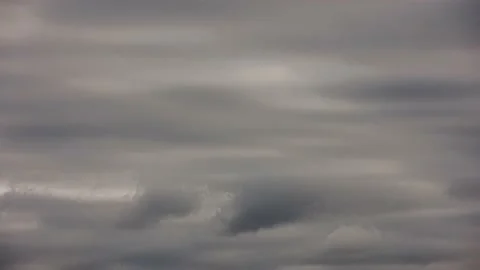 Overcast gray clouds flowing horizontally just above horizon - telephoto view Stock Footage 165486922