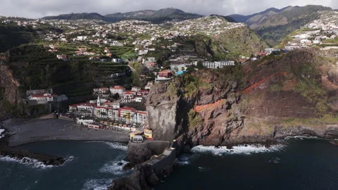 Overcast mountain settlement beside turbulent ocean with white houses Stock Footage 326425853