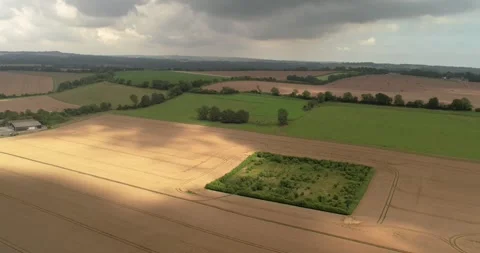 Overcast rain clouds casting shadows over Devizes agricultural farmland aerial Stock Footage 306915822